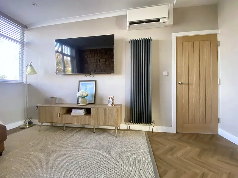 Living room TV wall with air-conditioning unit, oak sideboard and herringbone floor