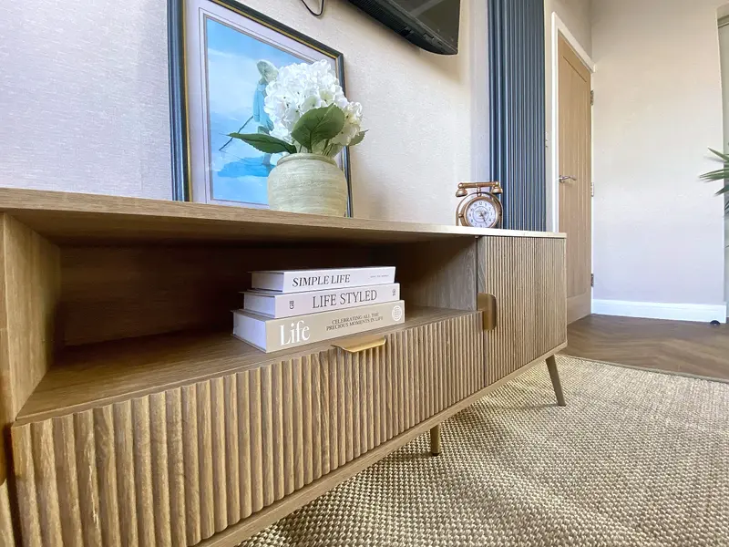Detail of the fluted oak sideboard with books and flowers
